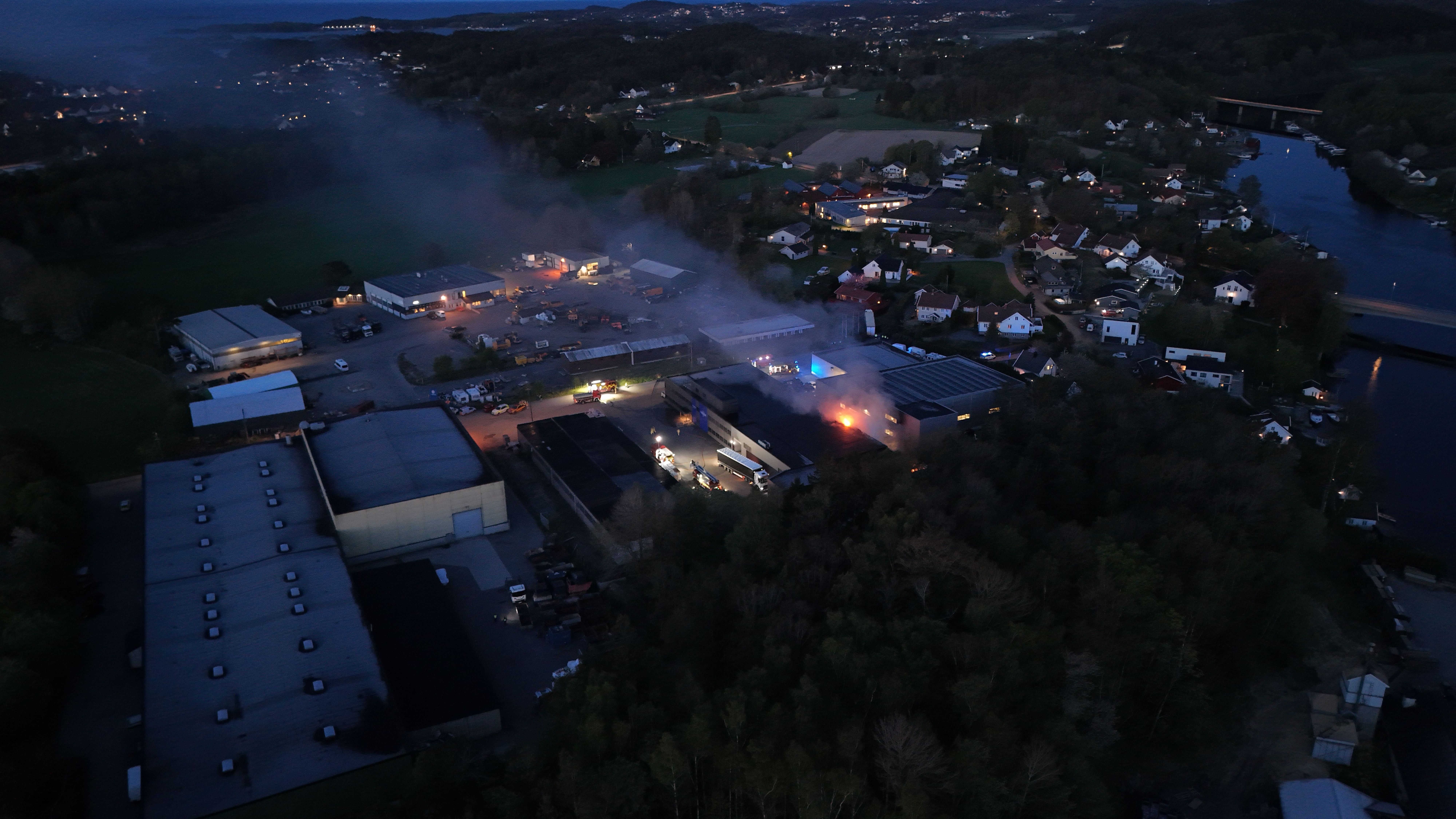 Bygning og flere biler står i brann: – Det er spred­nings­fare