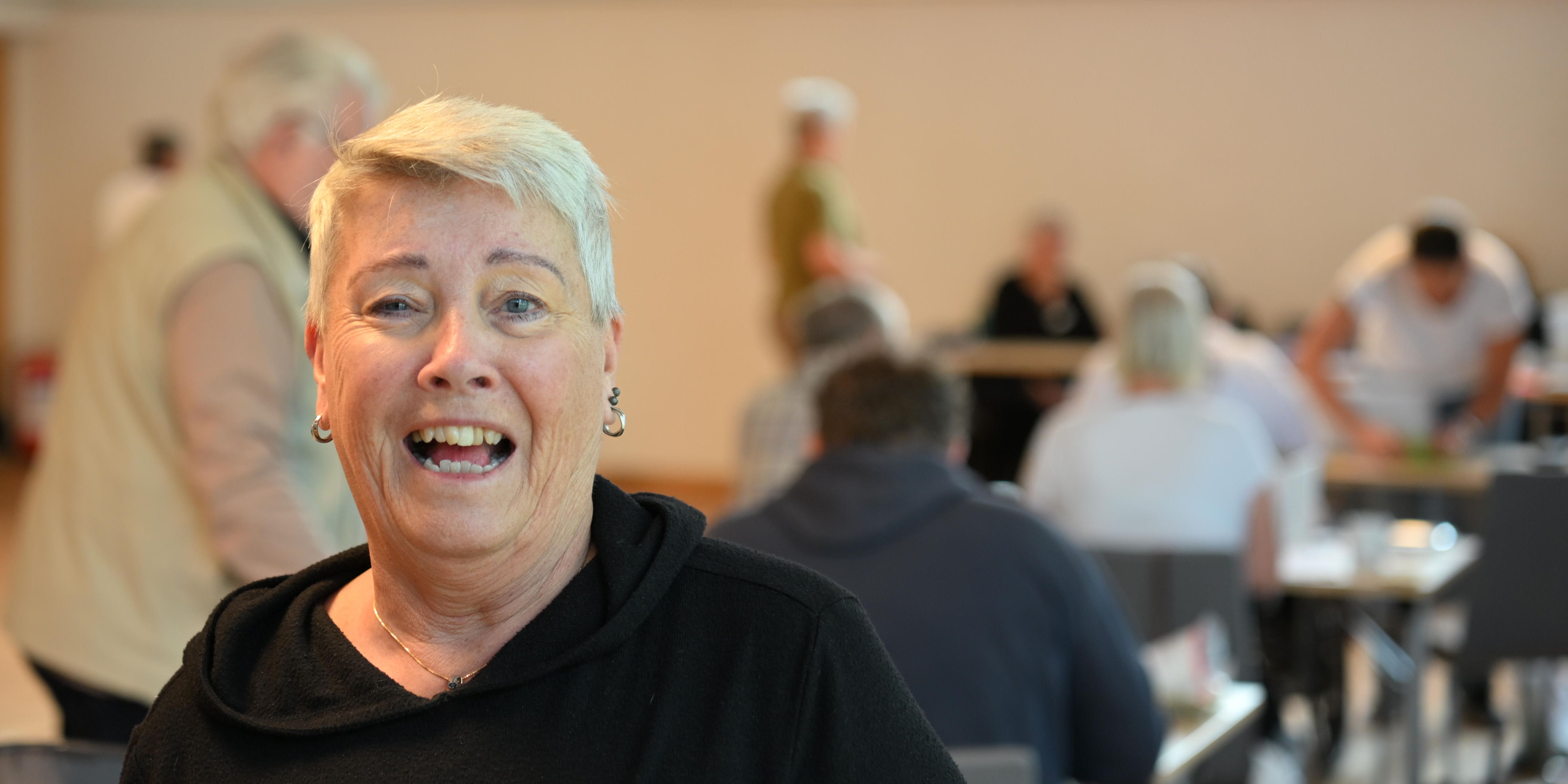 En korthårig kvinna tittar in i kameran.