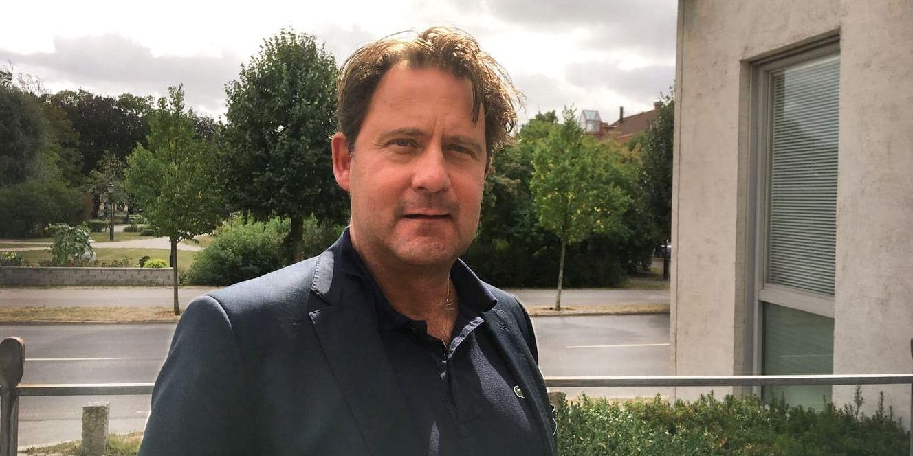Man med mörk kavaj tittar in i kameran