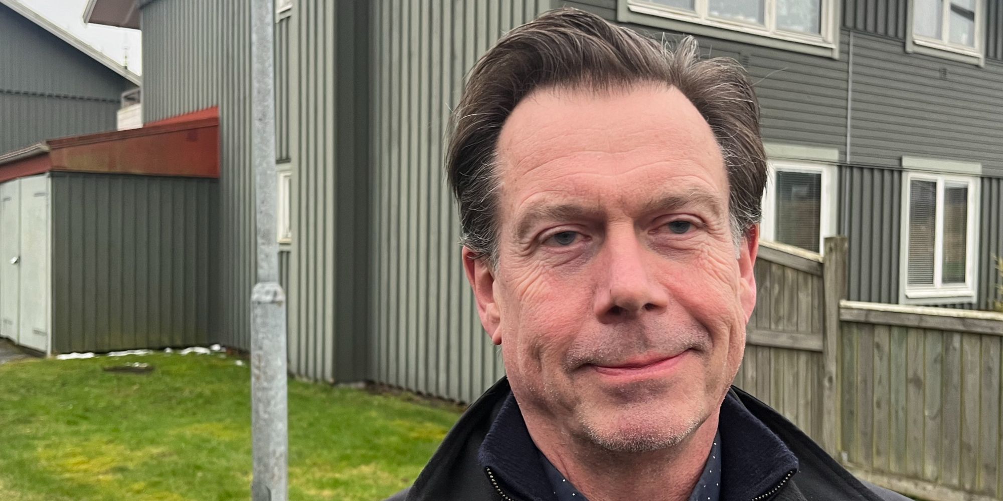 En man med mörkt hår poserar framför kameran.